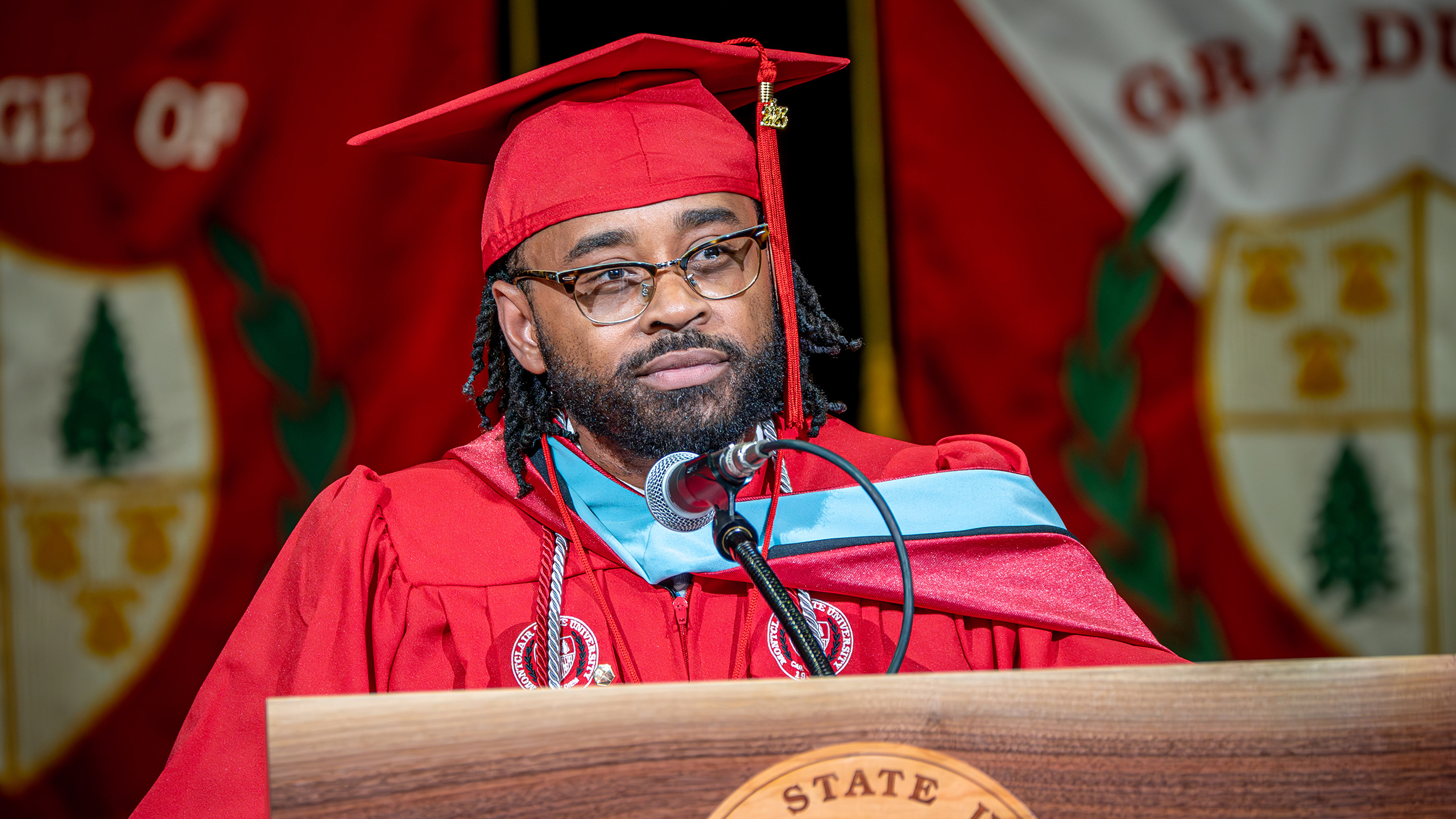 Desmond Durham stands behind podium at commencement