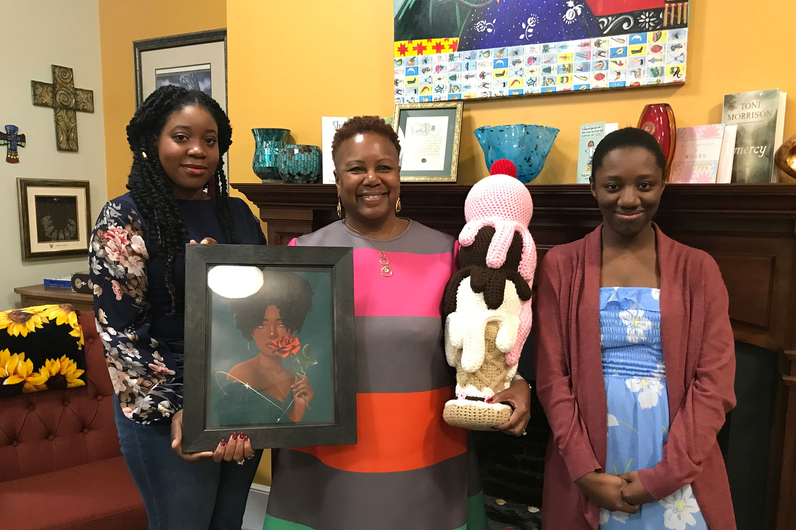 Chancellor Evans poses with alumni and art work