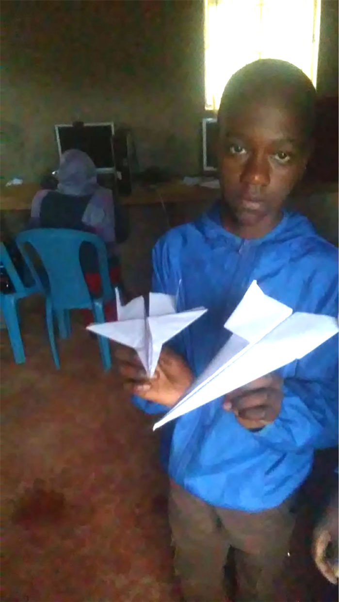 student in Kenya paper airplane activity