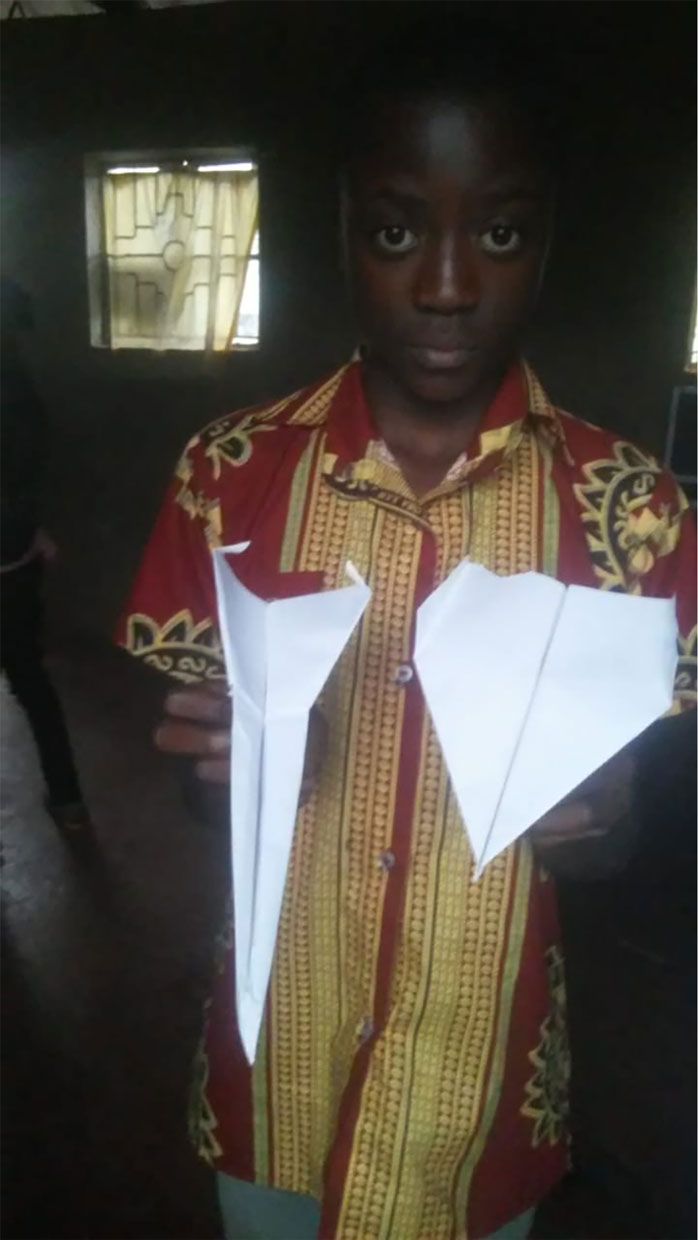 student in Kenya paper airplane activity