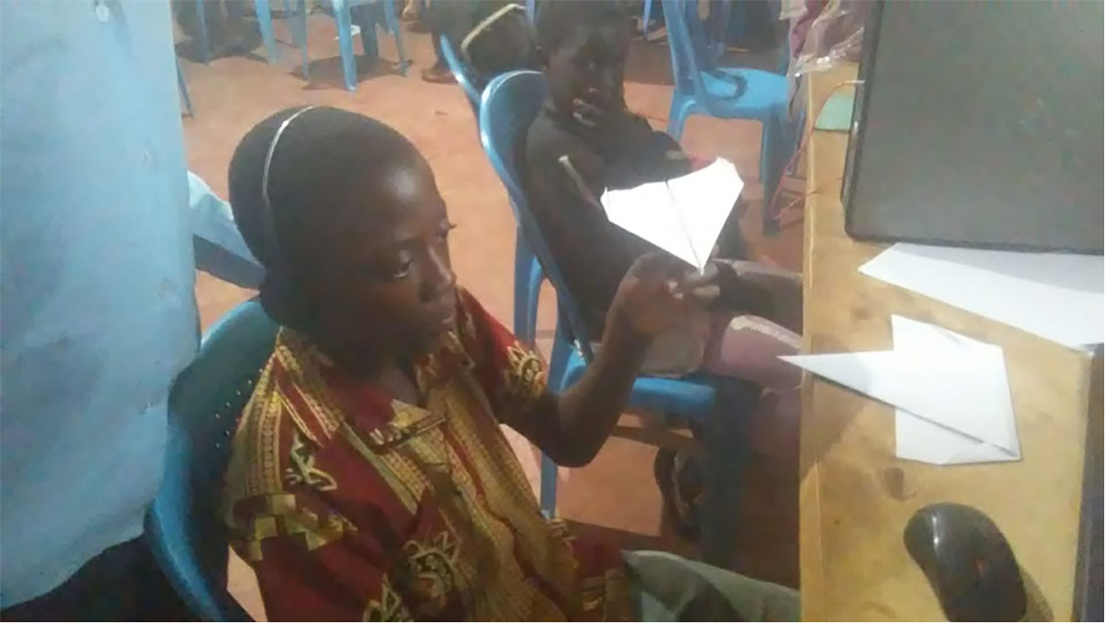 student in Kenya paper airplane activity