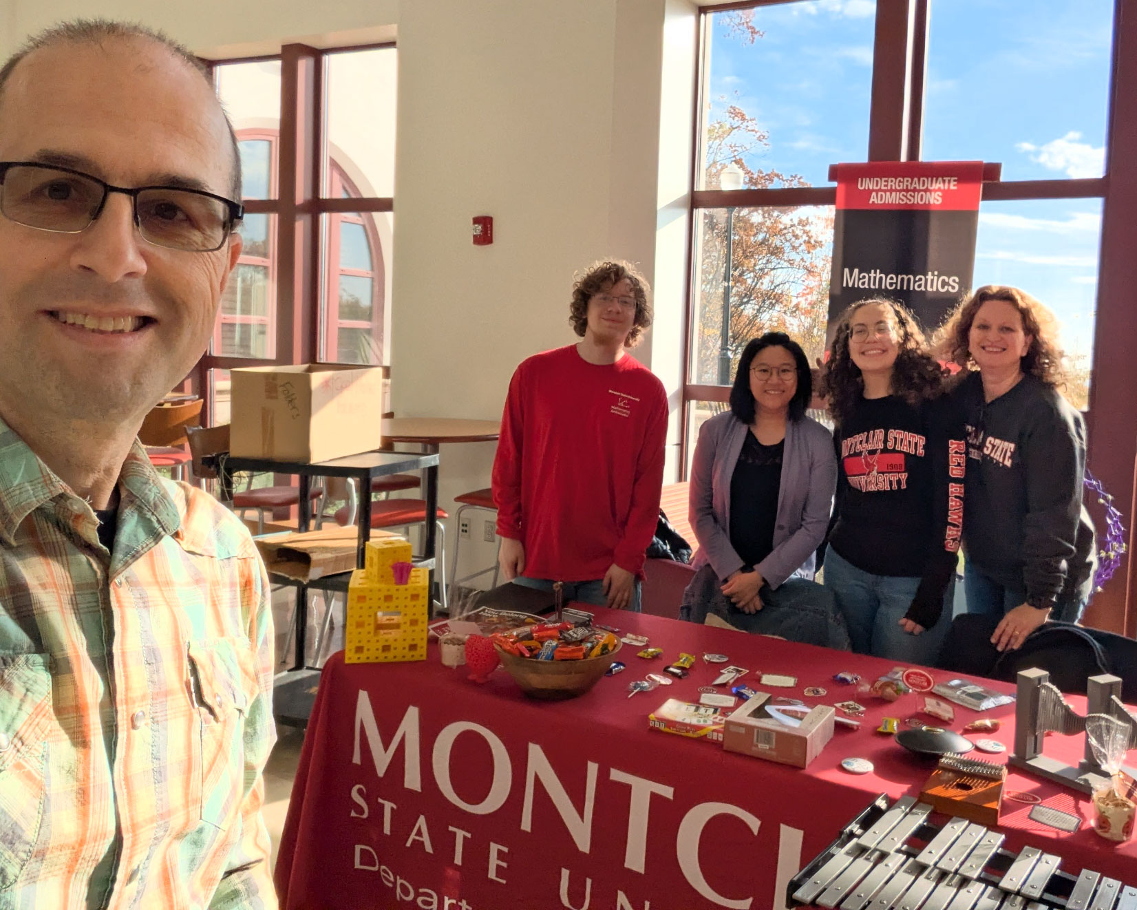 Dr. Nita selfie with group working math department table at open house