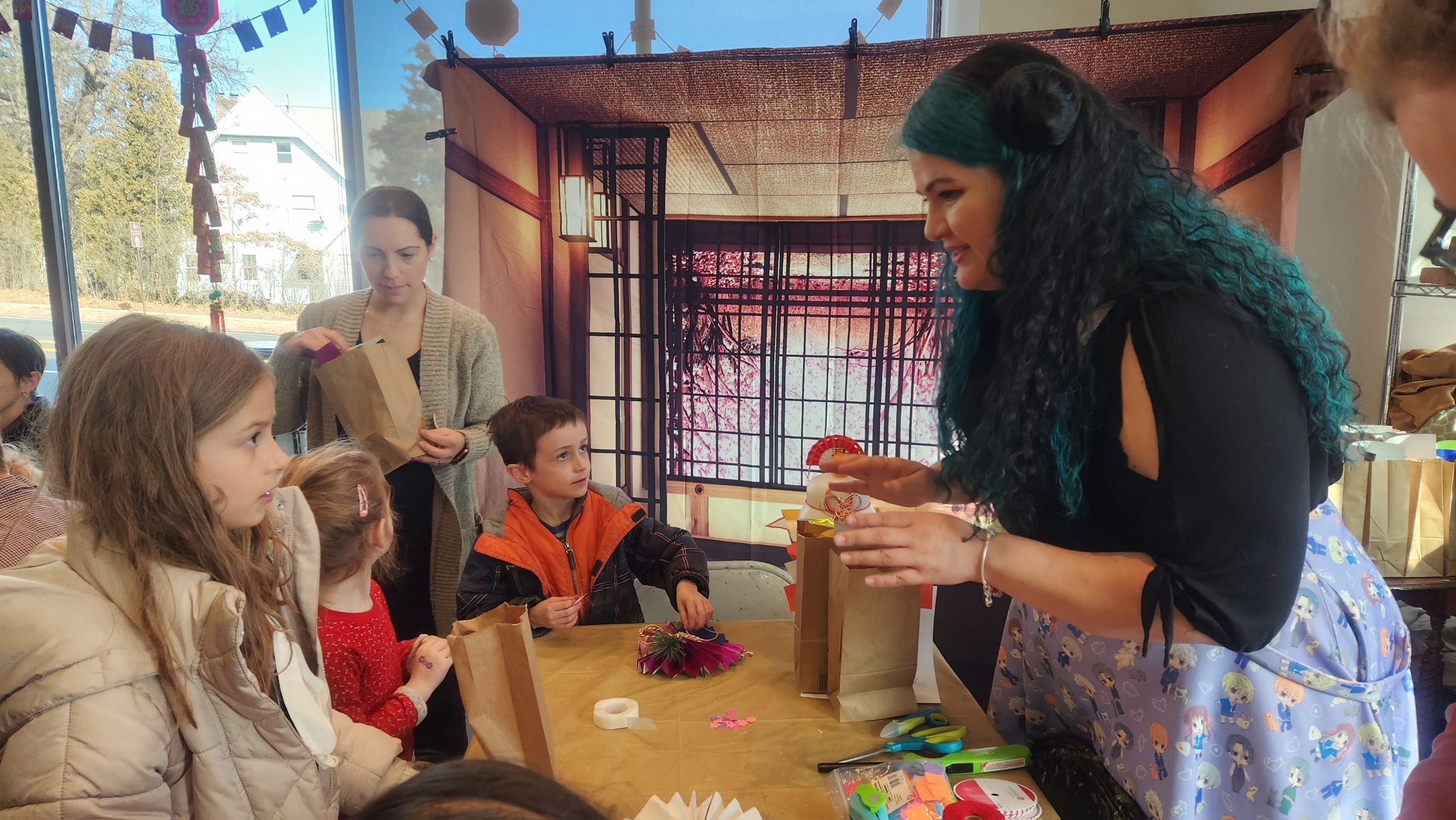 Student Katherine Martinez (right) shows community members how to make a Japanese new year wreath
