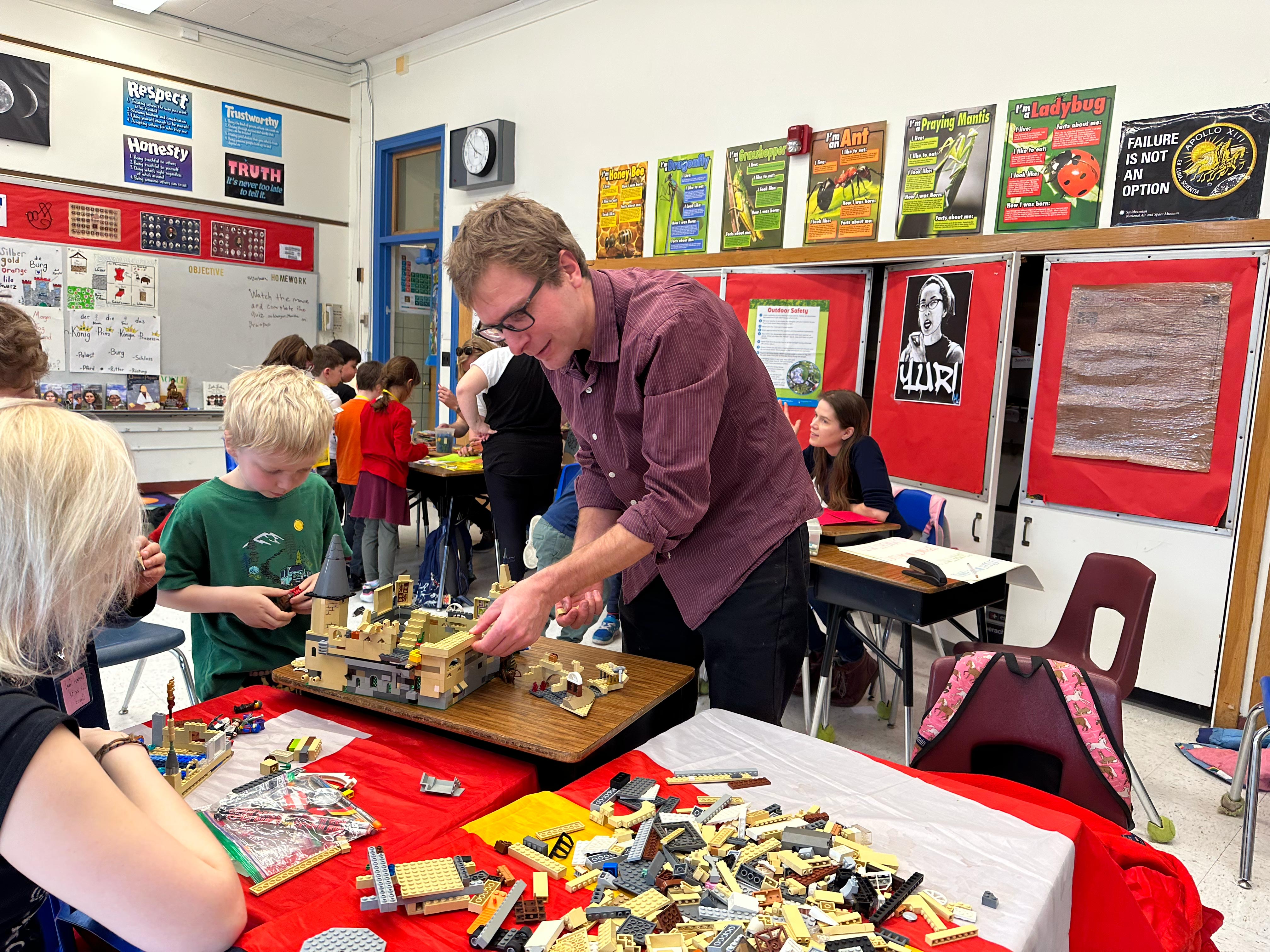Professor Thomas Herold in classroom working on lego project with students