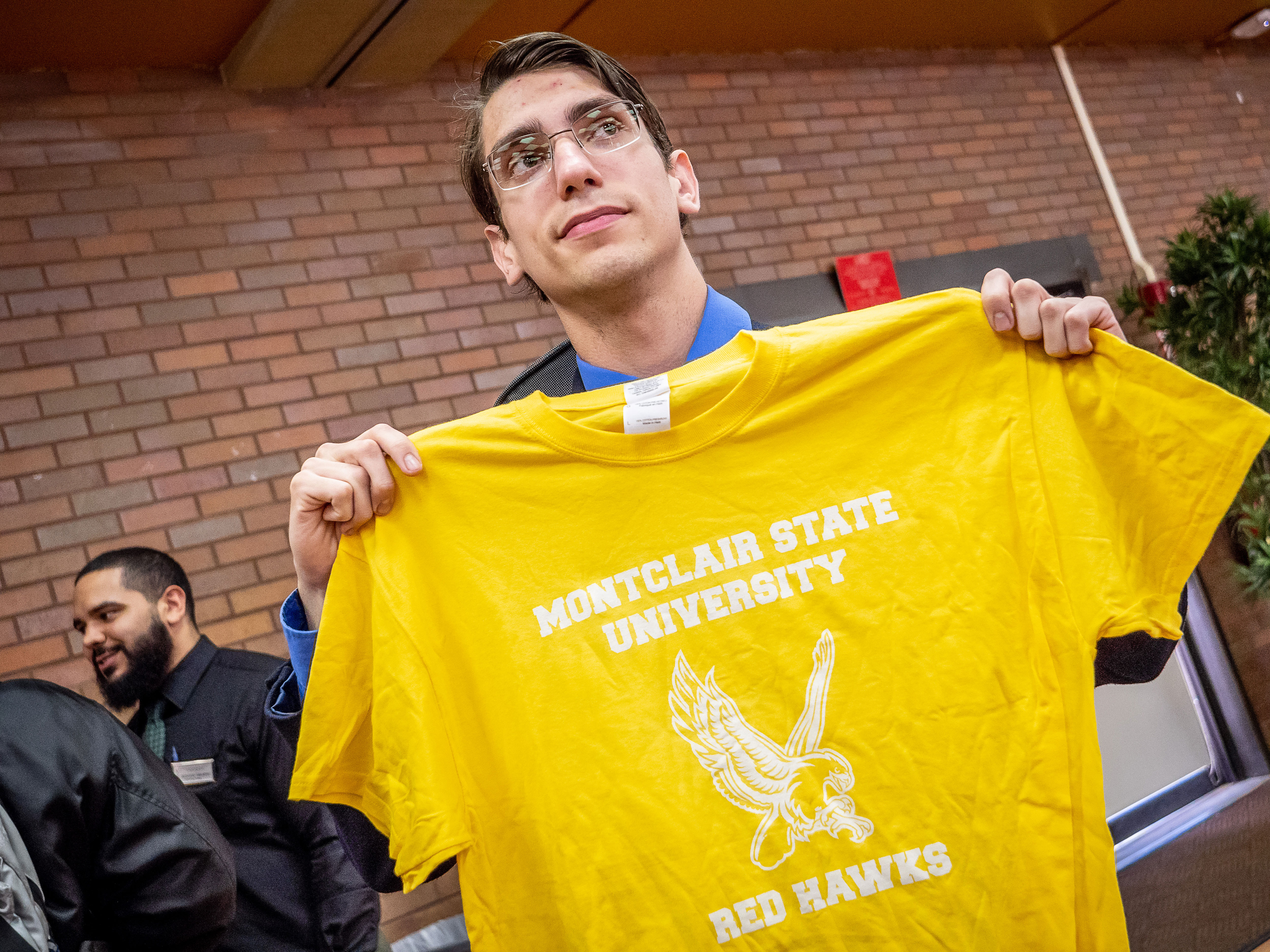 Student holding up yellow shirt