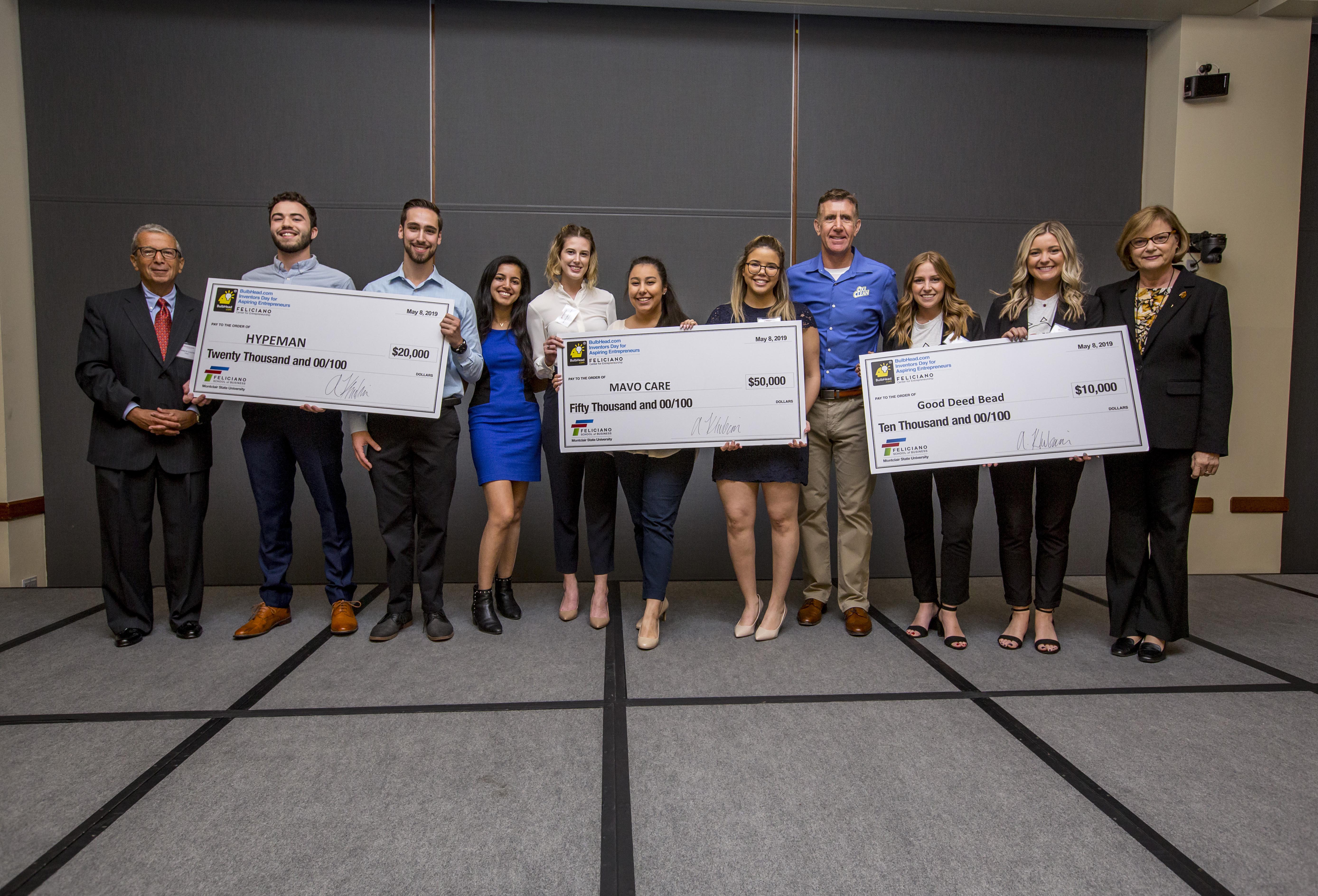 Winners and runners up holding checks