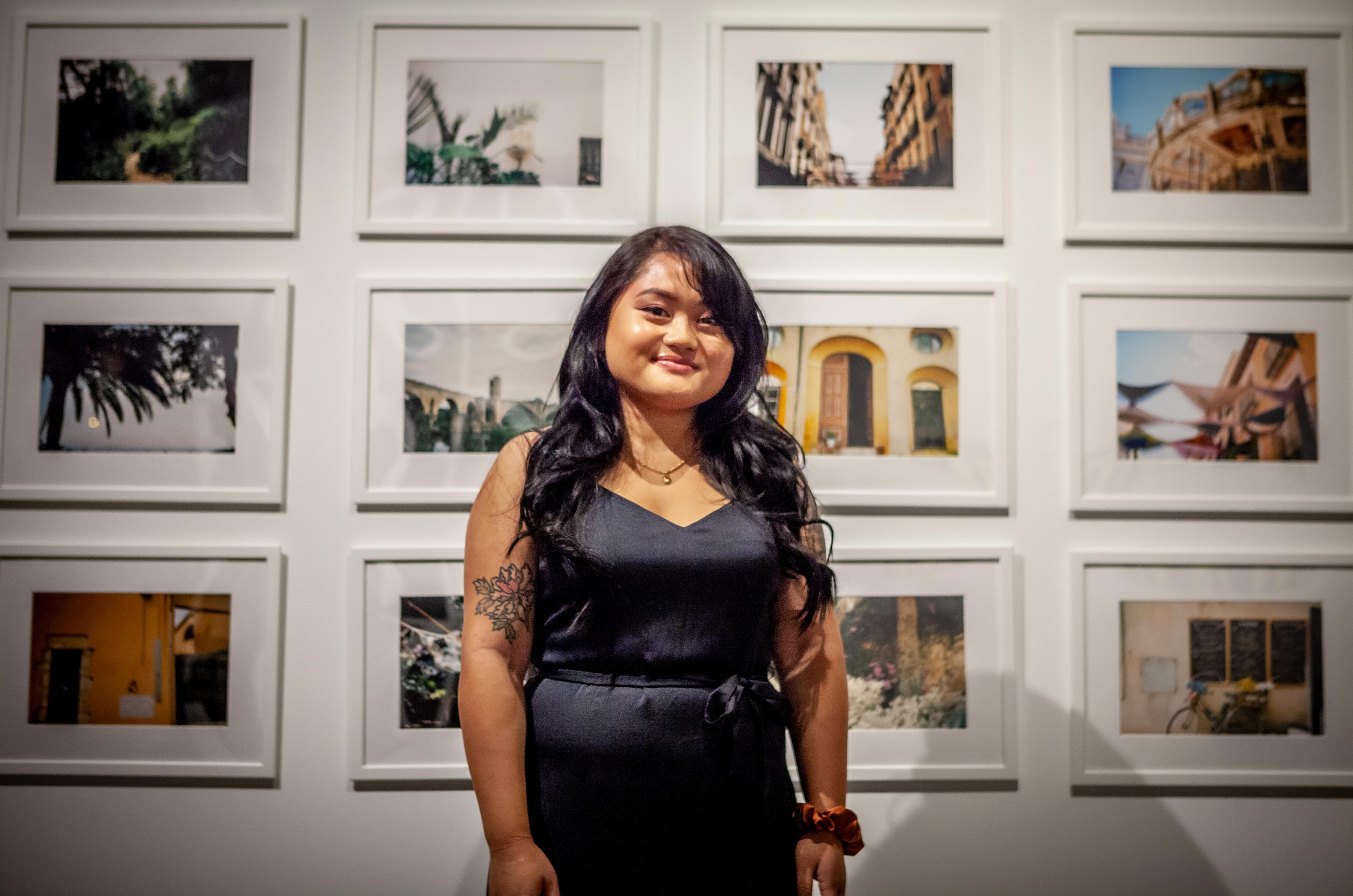 student artist in front of her work