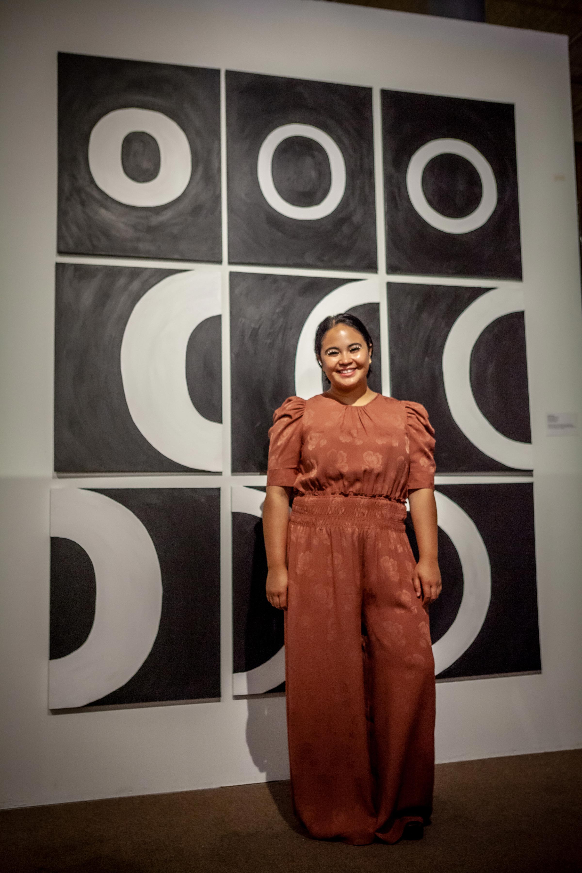 student artist in front of her work