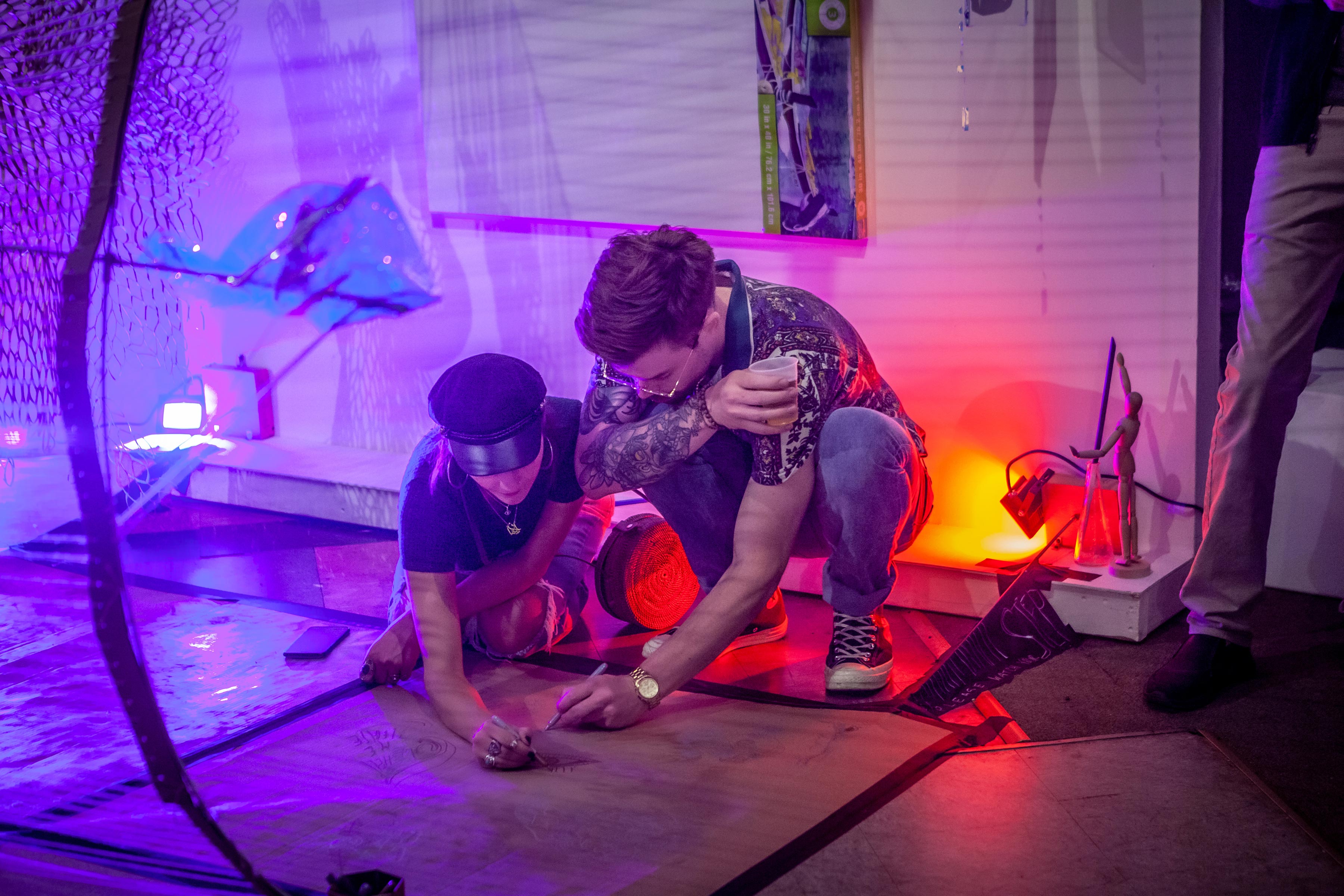 student artists working piece lit by strong colored lights