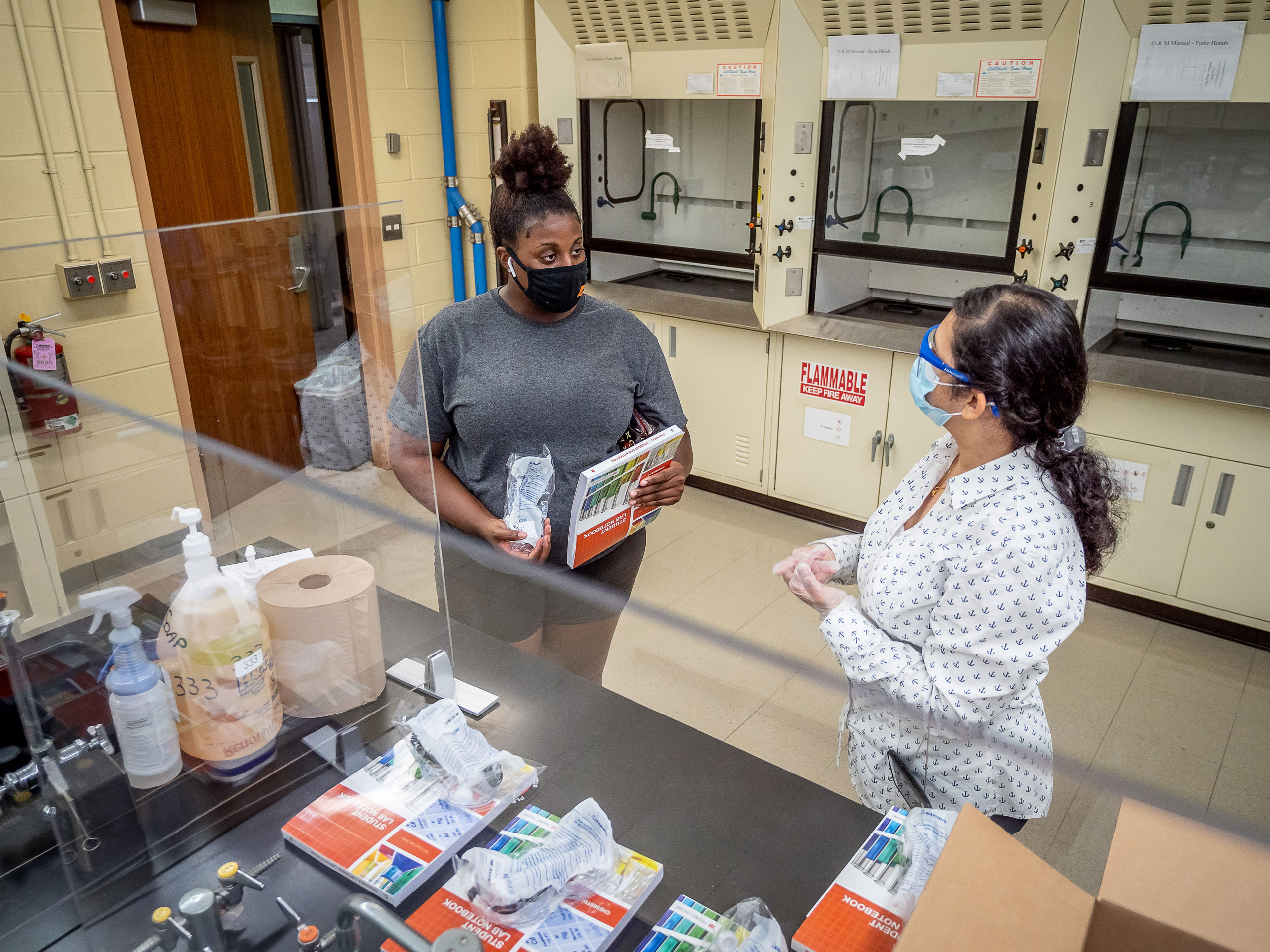Student and professor gathering supplies in chemistry lab