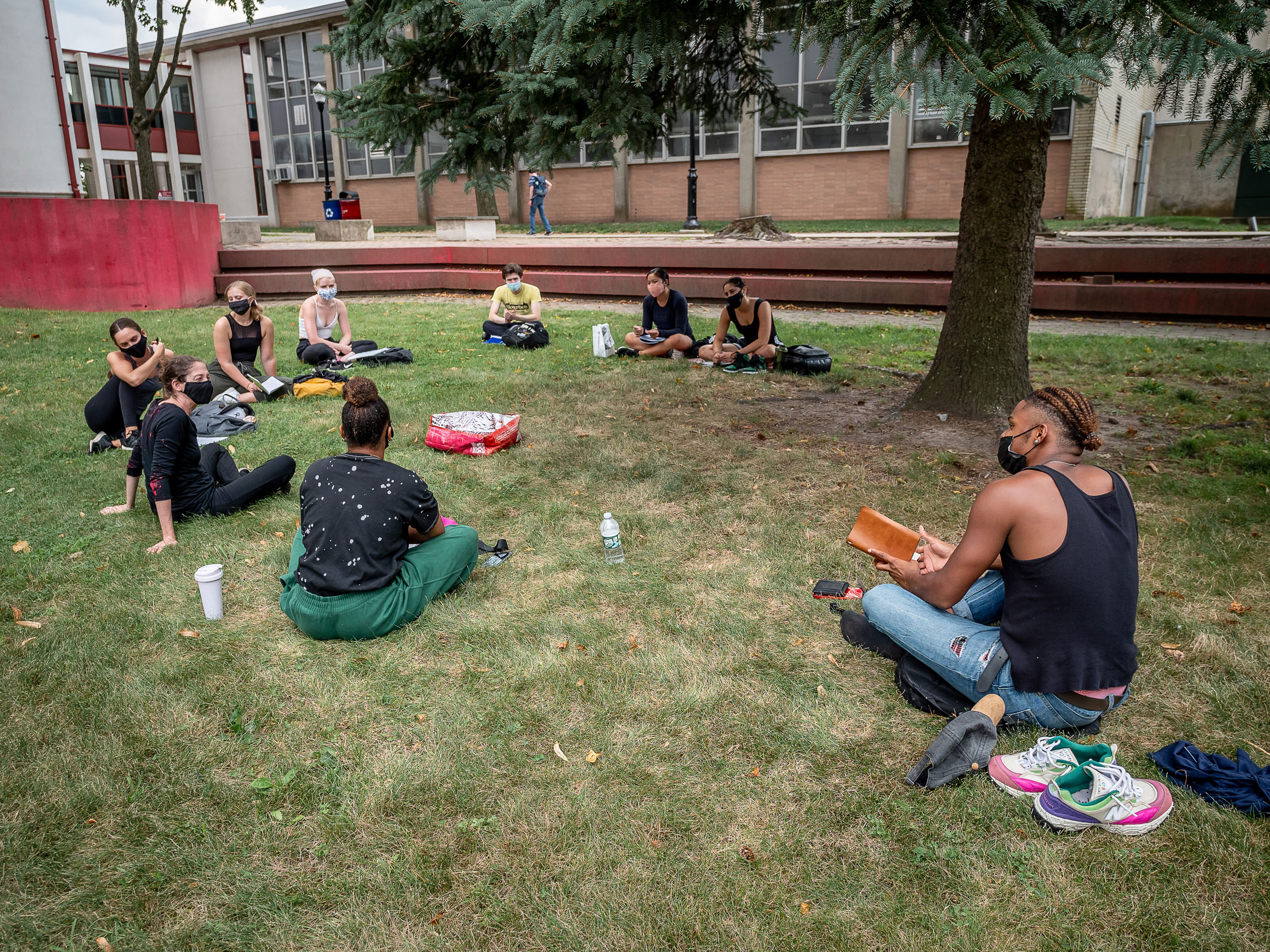 outdoor class sits in circle on the grass of the main quad