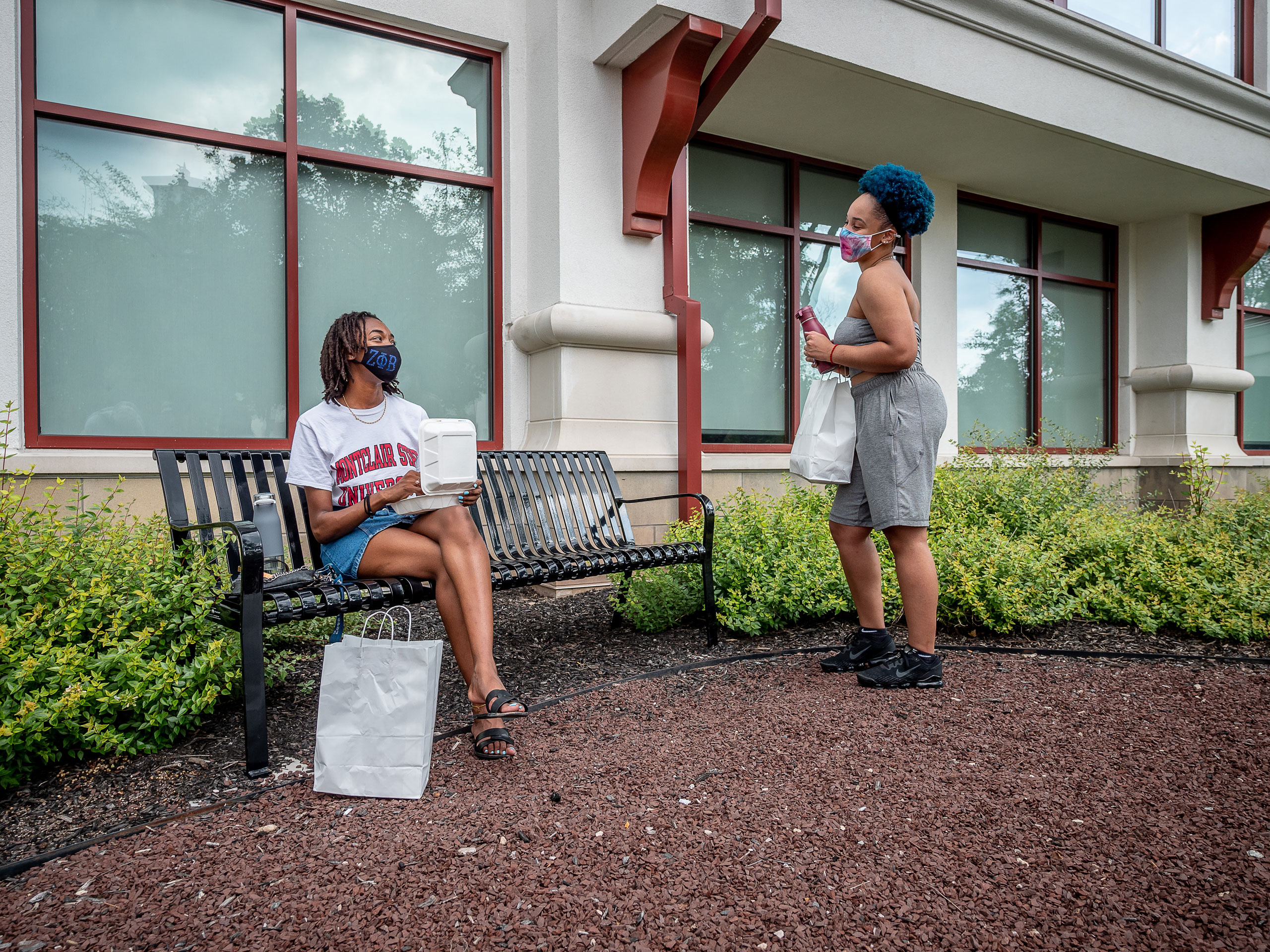 Two students talking at a bench outside Shmitt hall
