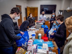 faculty and students around a table of supplies packing them into bags