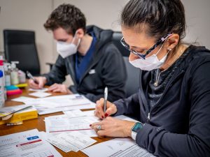 two nurses at a table filling out paperwork