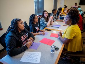 students and members of the African American and Latinx caucuses talking over long tables