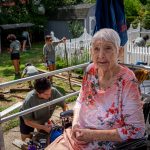 Elderly woman in foreground with students at work in the background