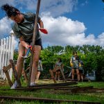 Student volunteer breaking apart scrap wood