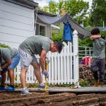 Two students removing floor boards from deck