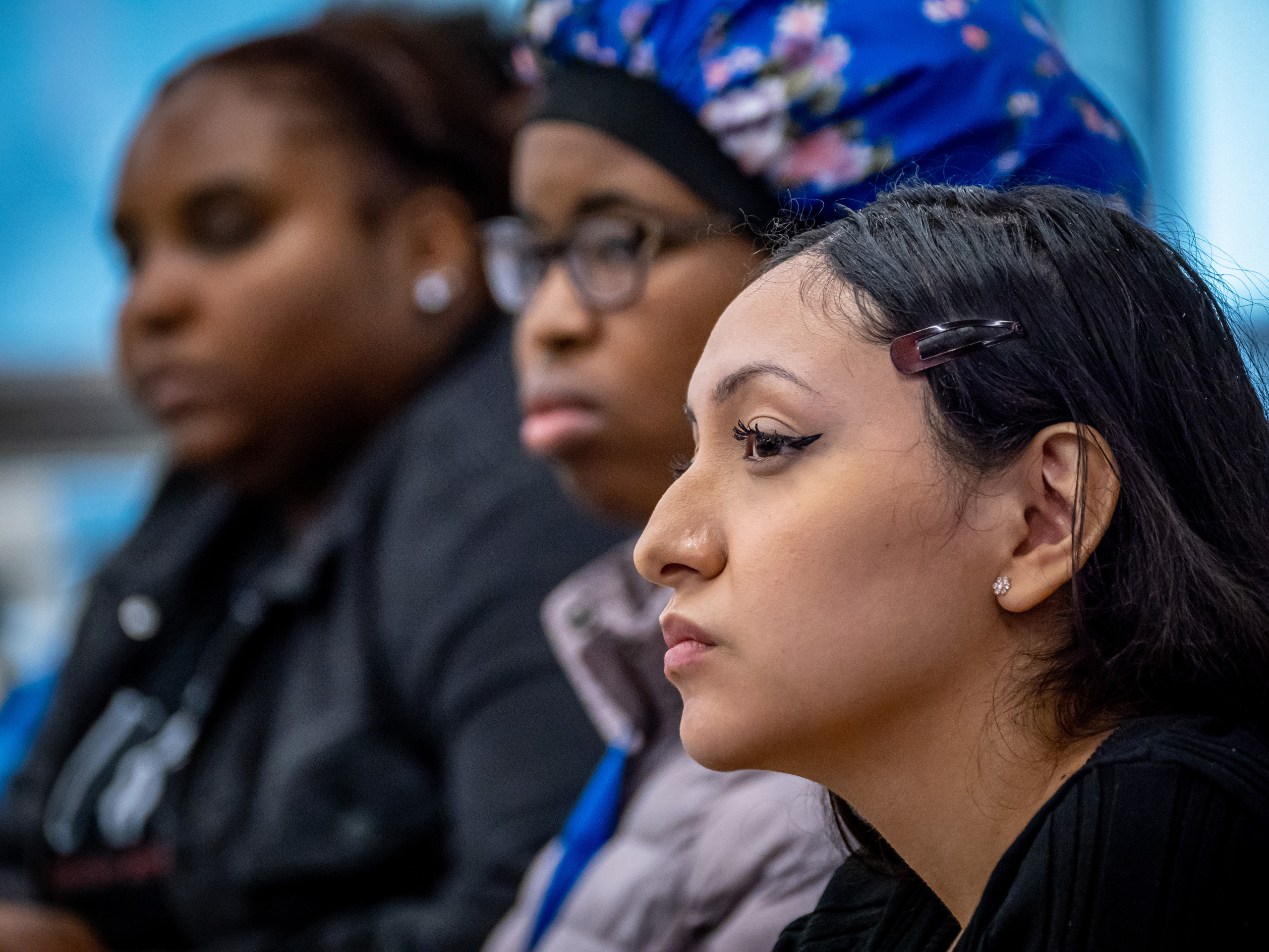 Students seated in a row, watching presentation