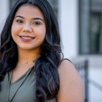 student in front of building