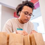 A student looks into paper bags.