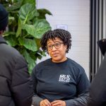 A woman talks with two students.