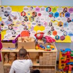 A young boy sits in front of a display of famous African Americans.