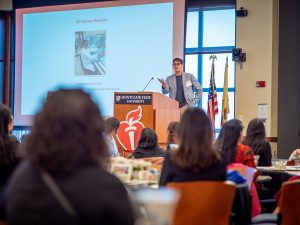 Professor gestures as he speaks to an audience.
