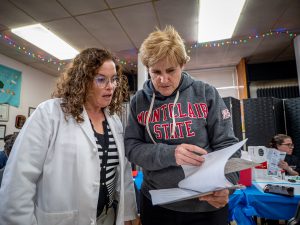 Two women review papers to prepare for a community screening.