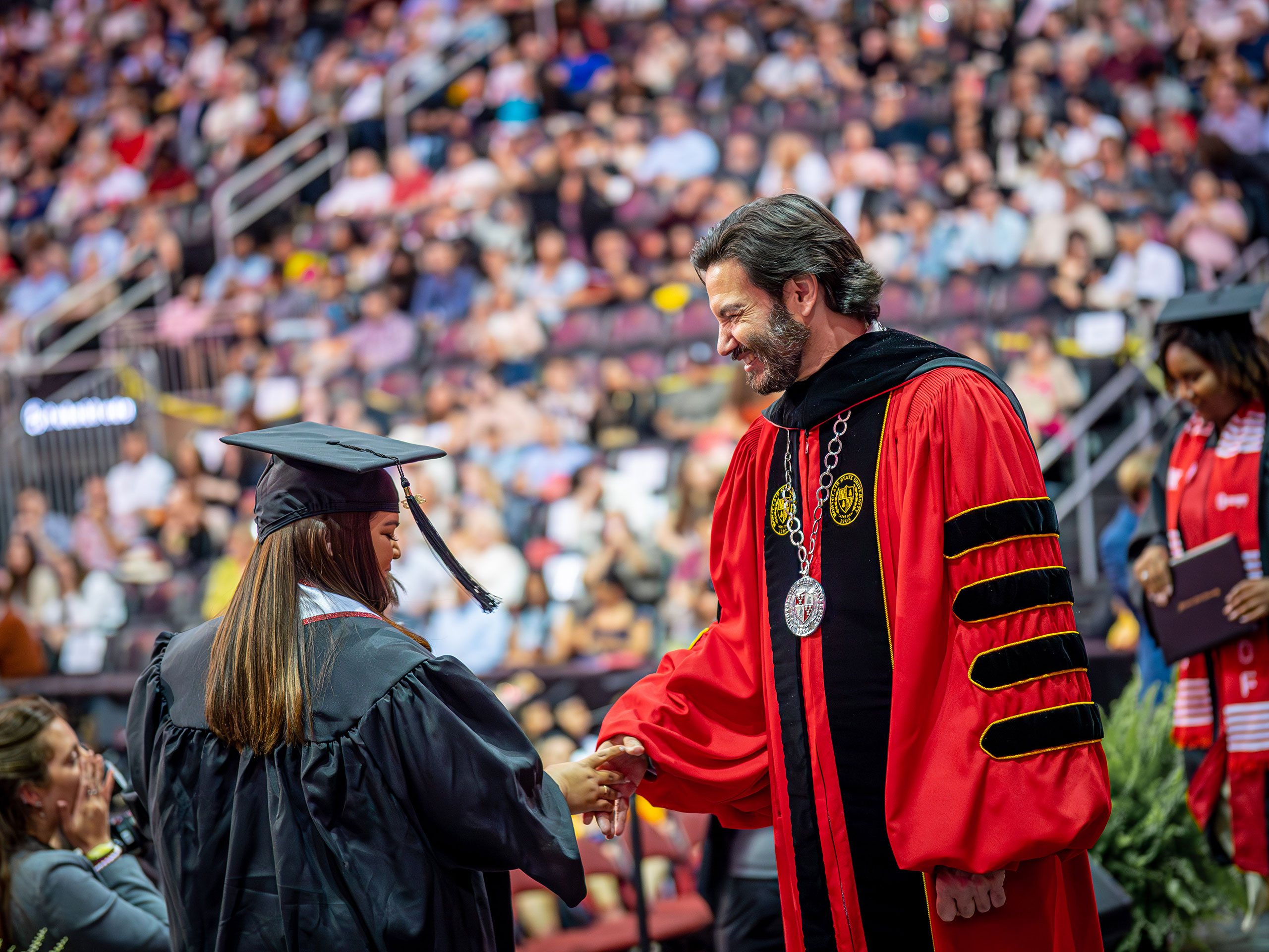 President Koppell shakes a graduate's hand on stage