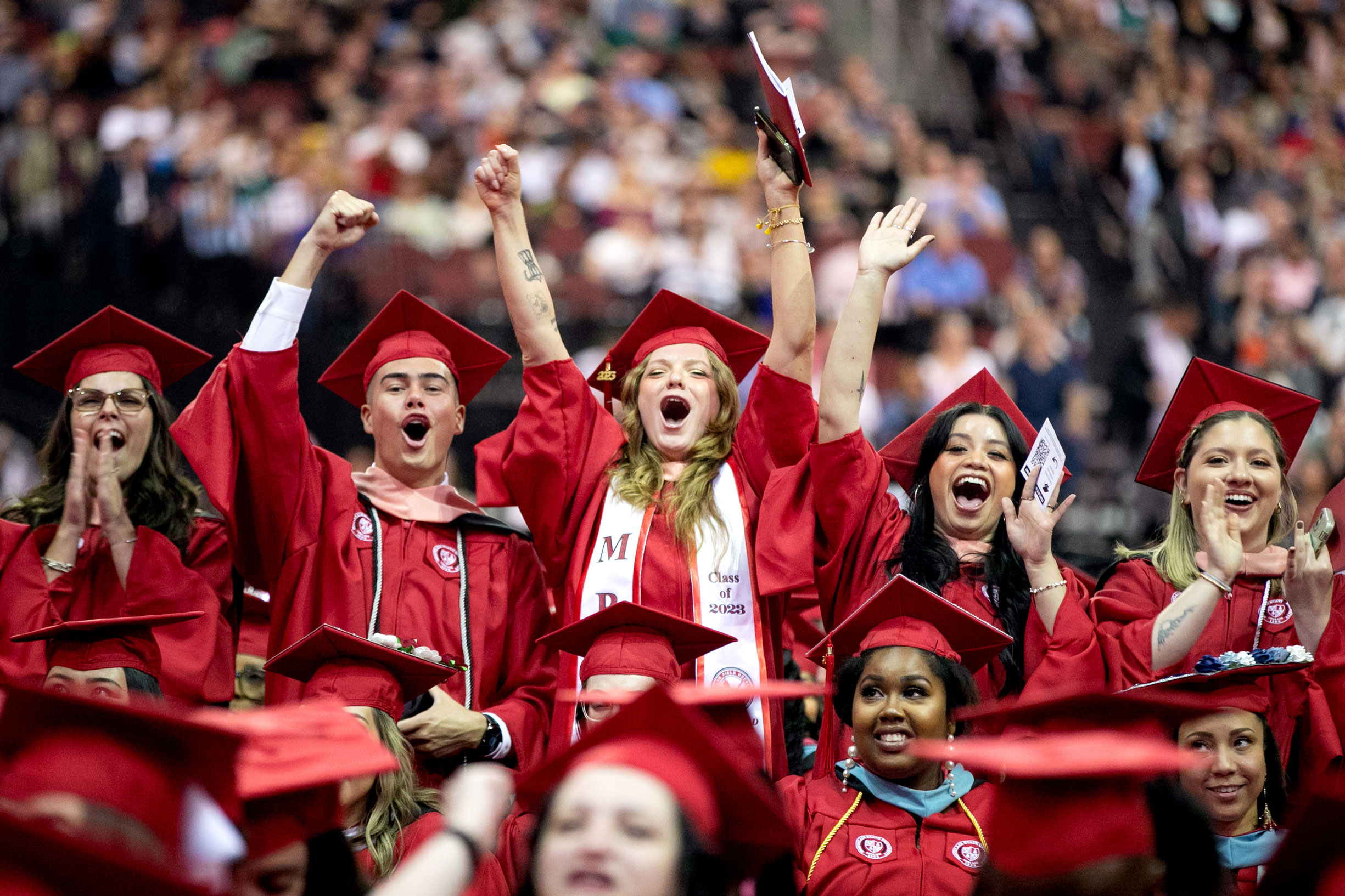 graduating students happy and clapping at commencement