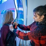 A student harnesses a fellow audiology student into the Bertec balance system.
