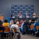 An audience listens to a panel of leaders on human trafficking.