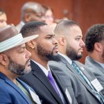 Men listen during a presentation.