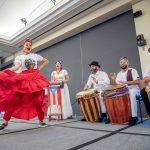 A woman dances onstage as drummers play behind her.