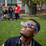A student looks up wearing his solar eclipse glasses.