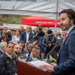 Jonathan Koppell speaks to the crowd inside a tent.