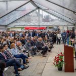 Charles J. Muth speaks to the crowd inside a tent.
