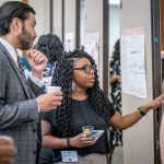 Montclair President Jonathan Koppell listens to a student as she explains her research.