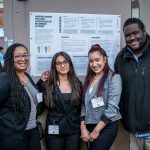 Students pose in front of their research poster with Associate Justice Studies Professor Jason Williams.