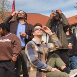 President Jonathan Koppell and students watch the eclipse.