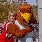  Vanessa Fingerlin hugs a white statue wearing a costumed bird head.