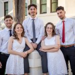 The Povolo quintuplets pose before a white building