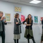 Professors Cathy Bebout, Bridget McGuire, Sharon Lindenfeld and Thomas Mueller stand before a student art display.