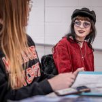 Katie talks with a classmate in German class.