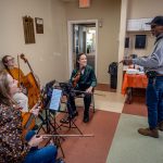 : A retired veteran stands and chats with members of the Trillium String Quartet.