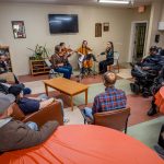 An audience of veterans listen as Trillium plays.