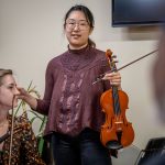 Violinist Judith Kim talks to the audience.
