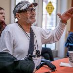 A veteran motions with his hand as he listens to a musical performance.