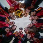 Team Rocky graduates pose with Rocky in a circle.